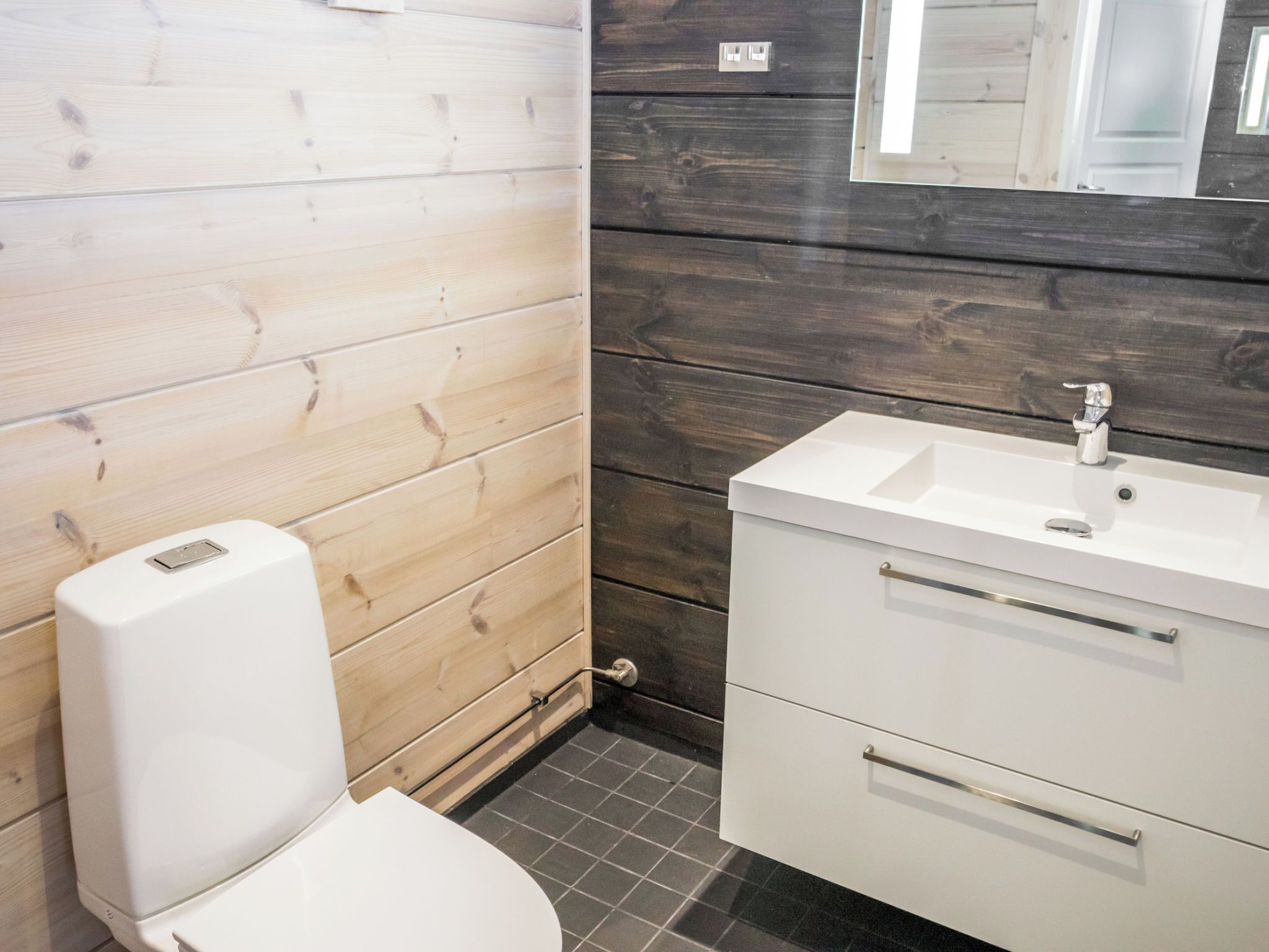 Un bagno con il water, un lavandino e uno specchio.