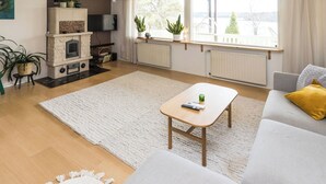 A living room with a fireplace, a sofa, a coffee table, and a view of the outdoors. - Villa aurinkorinne by Interhome (Fiskars)