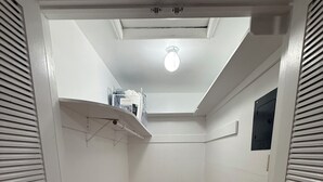 En smal hall med trägolv, vita väggar och en taklampa.