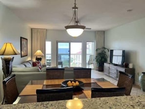 A hotel room with a dining area, a sofa, a television, and a view of the ocean. - Spacious Coastal Escape for Family Getaways (Miramar Beach)