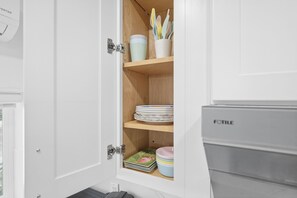 Un meuble de cuisine avec une étagère en bois, un égouttoir à vaisselle et un réfrigérateur.