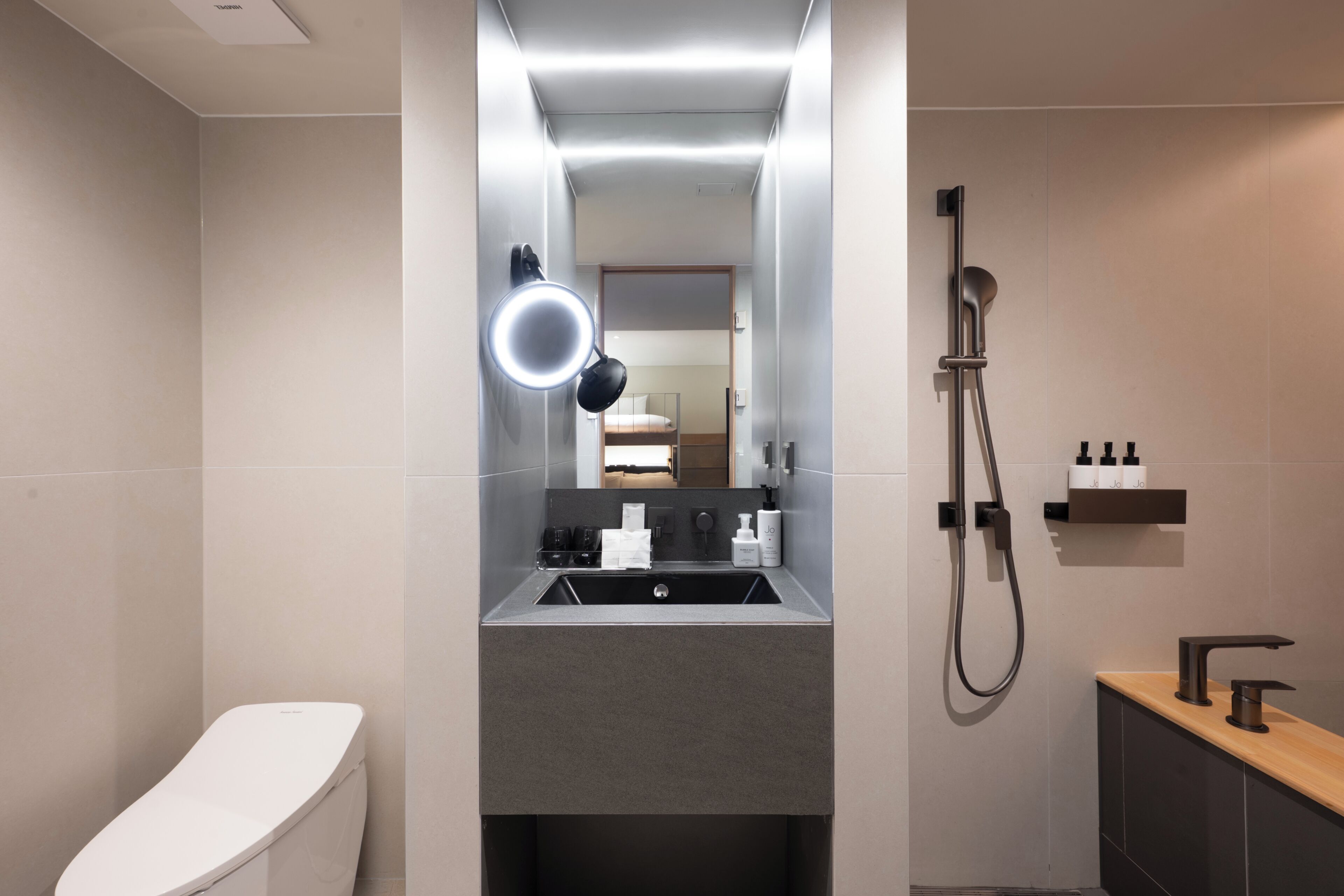 A modern bathroom with a toilet, sink, and shower.