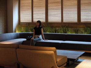 Una sala moderna con un sofá, una mesita de centro y una planta en maceta.