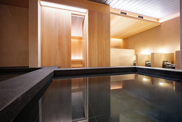 A modern indoor pool area with a clear water surface, wooden panel walls, and a ceiling with a slatted design. - Hotel TOV (Busan)