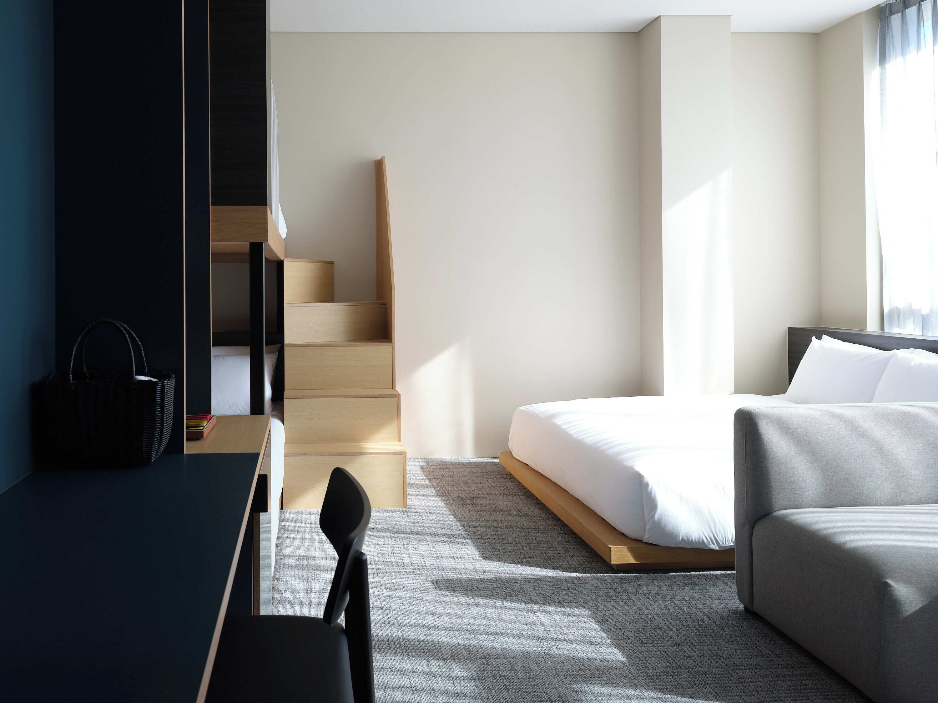 Een moderne hotelkamer met een bed, een bureau, een stoel en een trap.