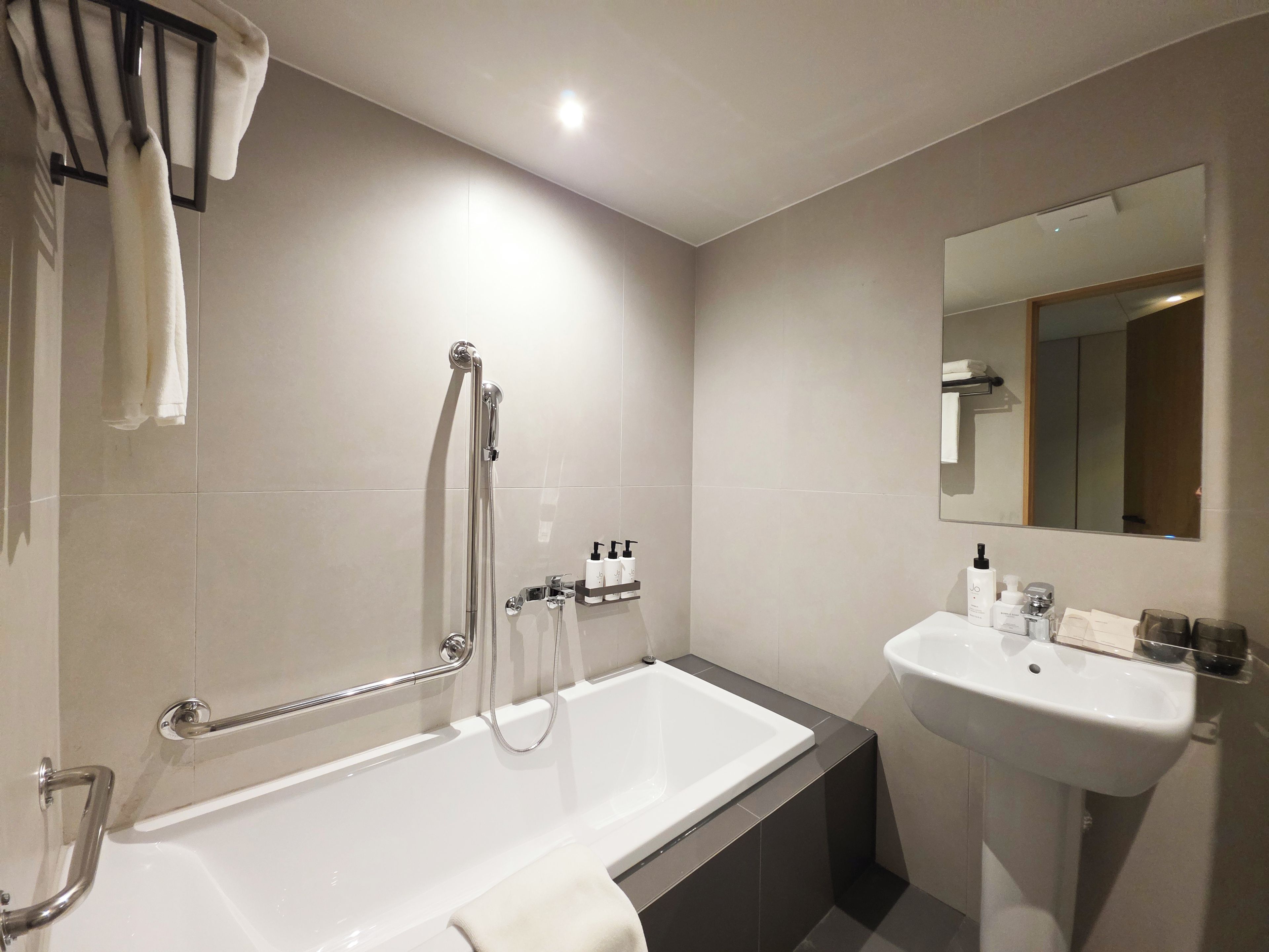 Un bagno moderno con vasca, lavabo e doccia.