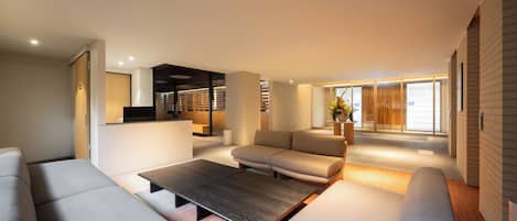 Una sala de estar moderna con un sofá modular, una mesa de centro y un televisor.