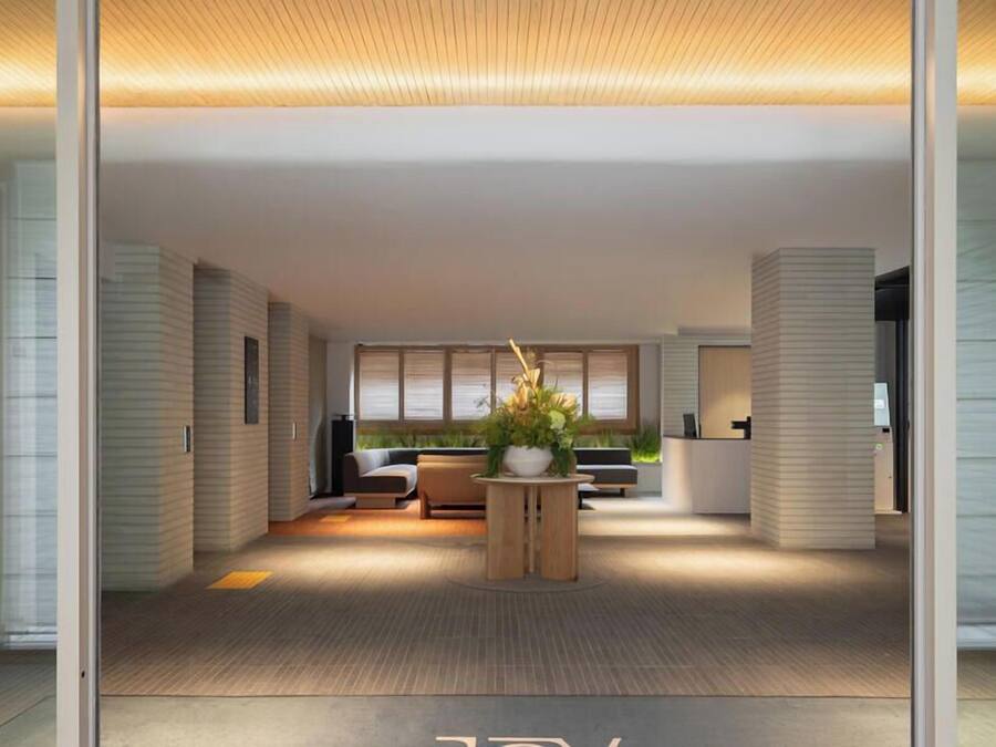 A modern interior with a reception desk, seating area, and large windows.