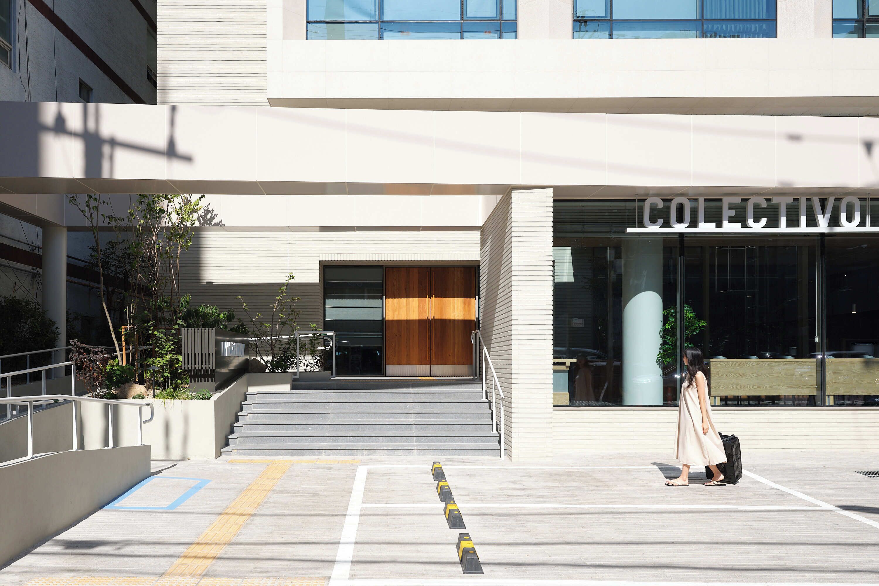 A modern building with a sign reading 'COLLECTIVO' at the entrance.