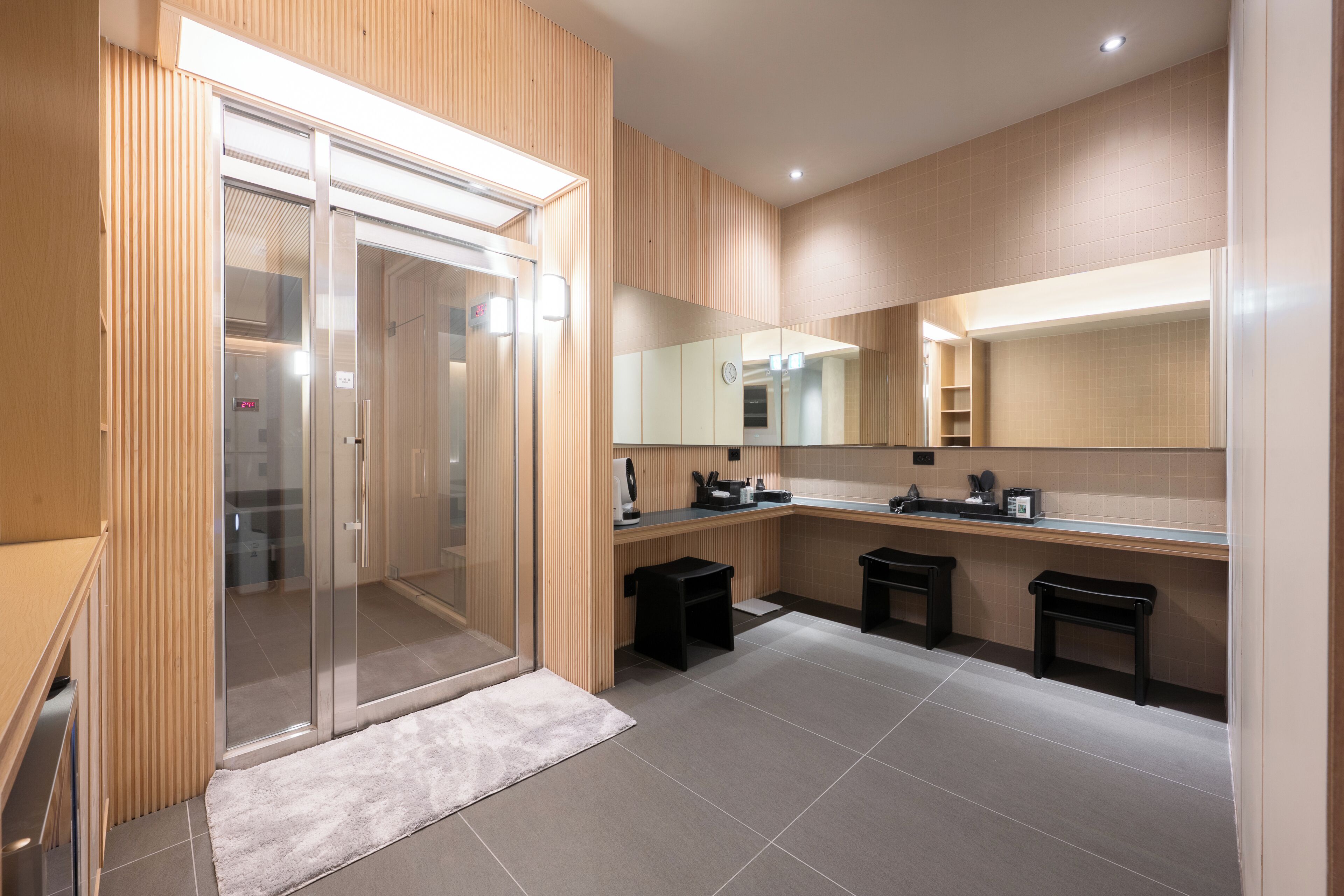 Une salle de bain moderne avec une douche à parois de verre, un lavabo avec un miroir et des toilettes.