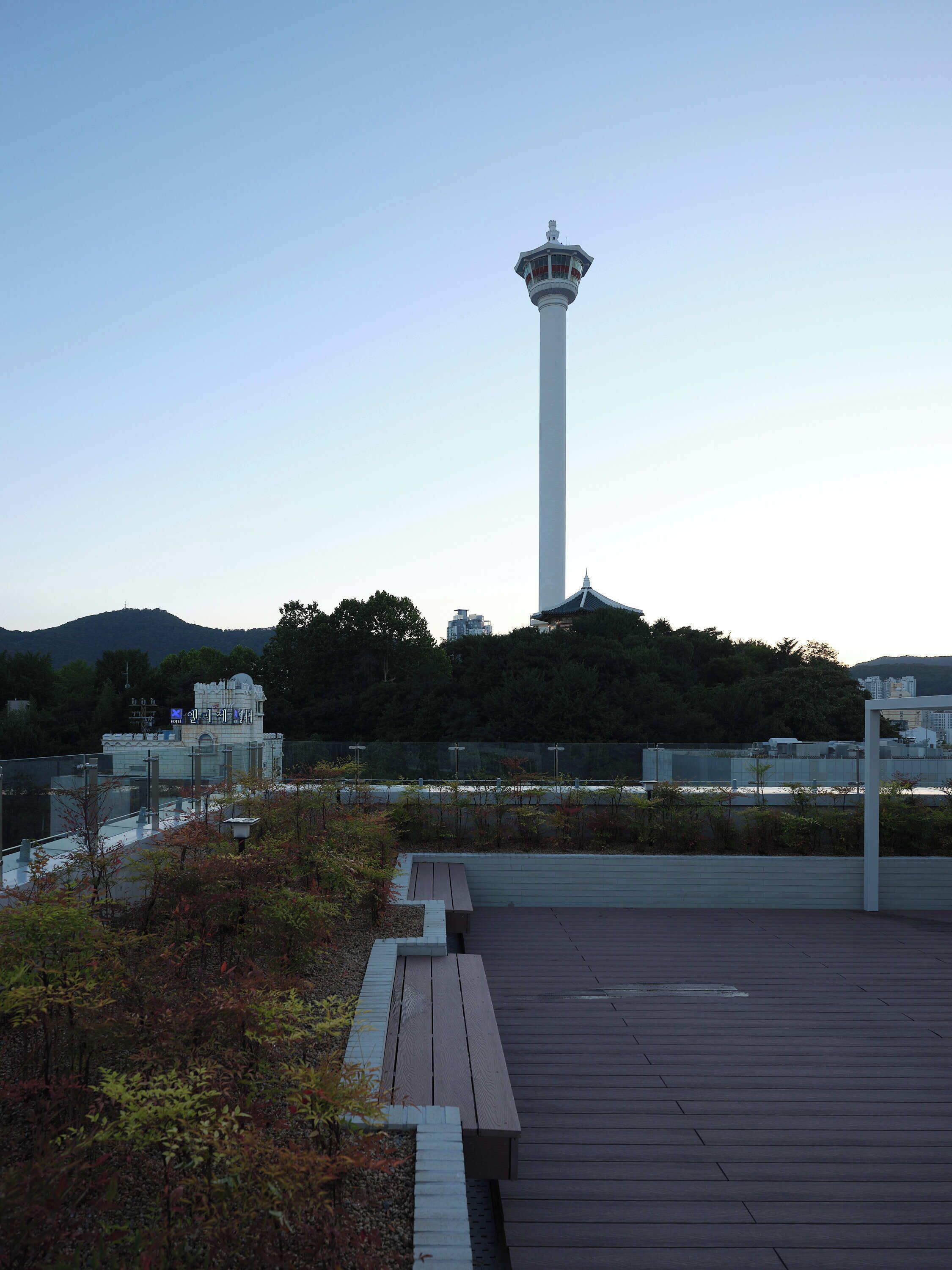 A tall white tower with a viewing platform and a wooden deck with benches.