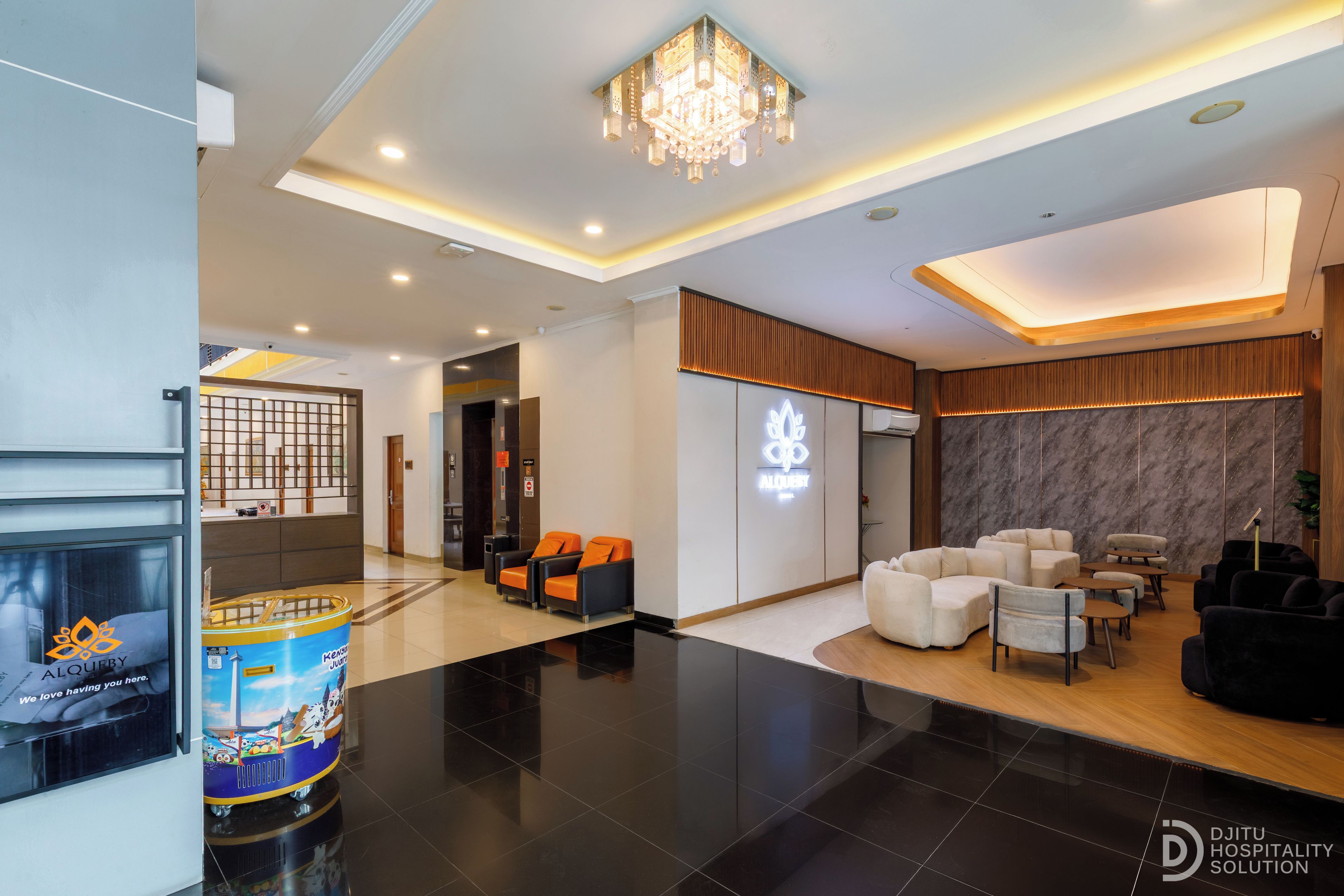Eine moderne Hotelhalle mit einer Rezeption, einer Sitzecke und einem Kronleuchter.