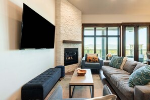 Ein Wohnzimmer mit Kamin, Flachbildfernseher und einer Couch.