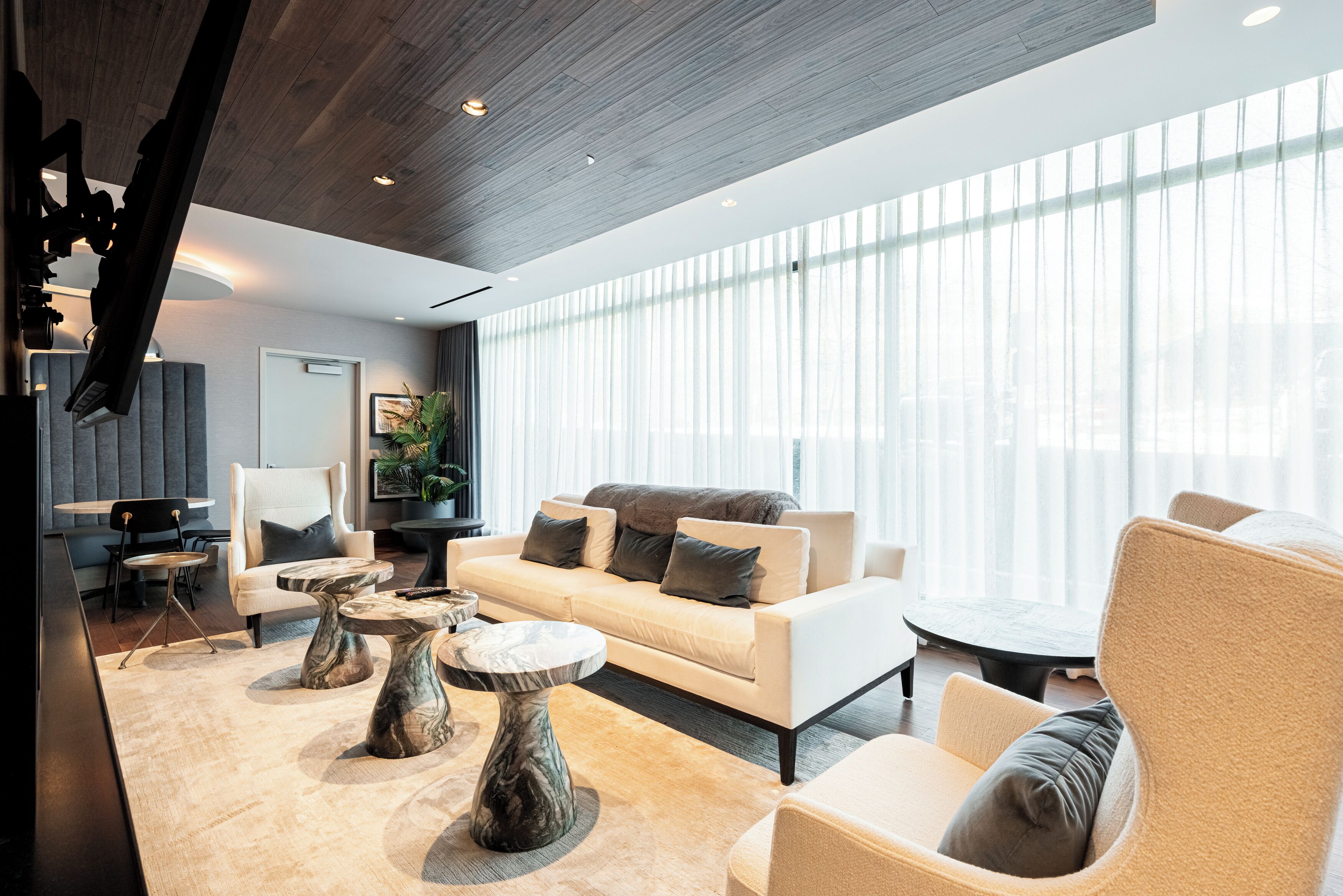 Una sala de estar moderna con un sofá, sillones y una mesa de centro.