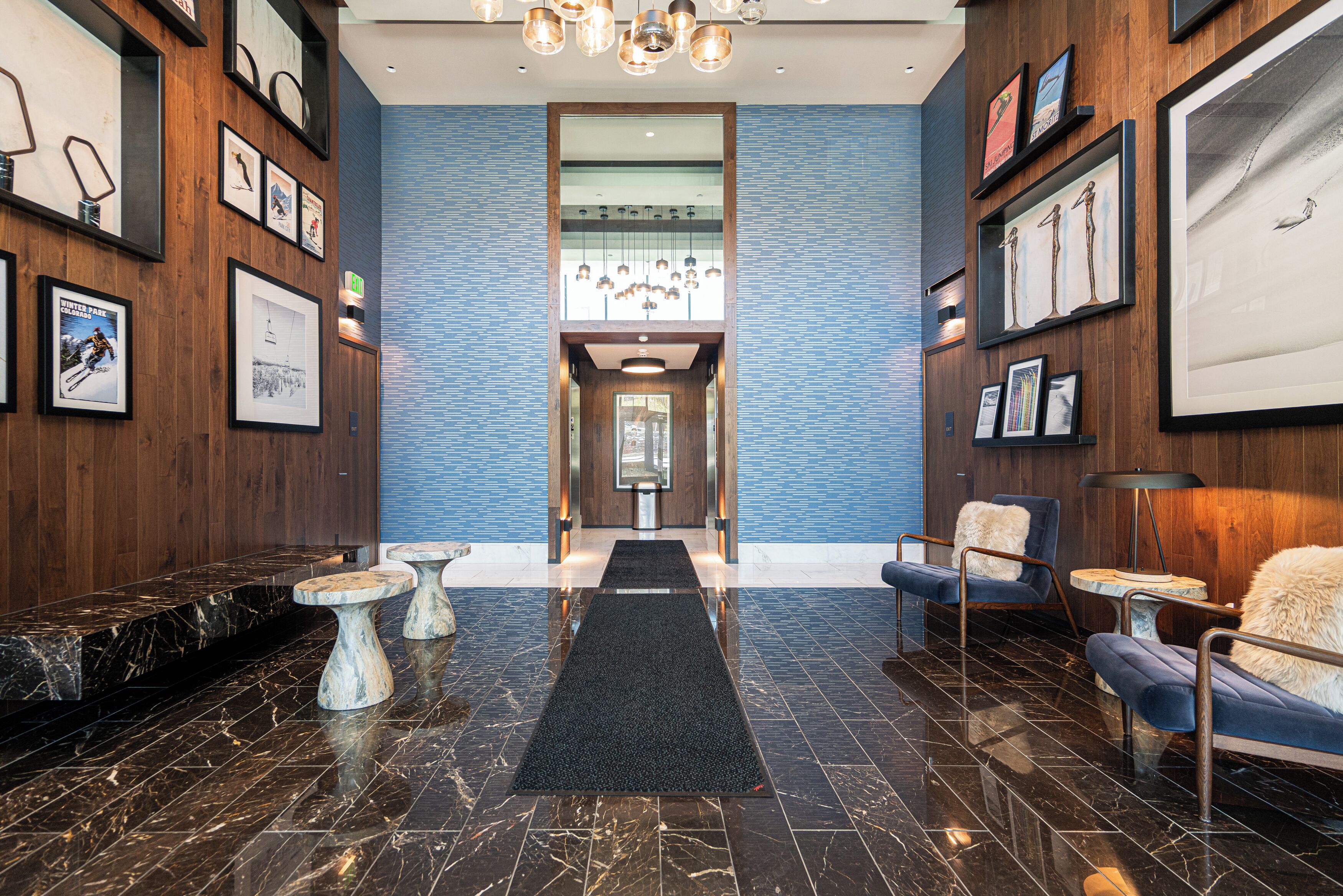 A lobby with a marble floor, framed artwork, and seating areas.