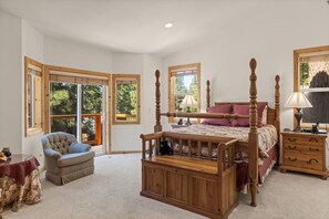 Une chambre à coucher avec un lit à baldaquin, une chaise, une table de chevet et une table.