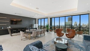 Una sala de estar moderna con comedor, ventanas amplias y vista a la ciudad.