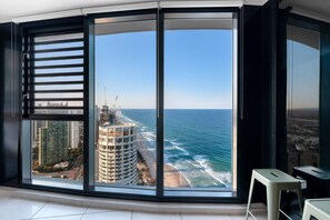 A room with a large window offering a view of the ocean and cityscape. - Incredible Views in 2b Luxury Home in Meriton (Surfers Paradise)