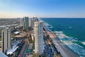 A coastal cityscape with high-rise buildings, a beach, and a clear sky. - Incredible Views in 2b Luxury Home in Meriton (Surfers Paradise)