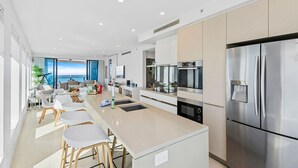 Una cocina moderna con una isla central, electrodomésticos de acero inoxidable y vistas al exterior.
