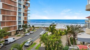 A coastal hotel with multiple floors, a view of the ocean, a parking area, and palm trees. - Palm Beach 3b Apartment. Parking. Wifi. (Palm Beach)