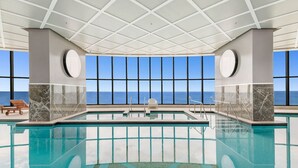 A large indoor swimming pool with a clear view of the ocean through large windows. - Stunning Beachfront level48 with parking /L (Surfers Paradise)