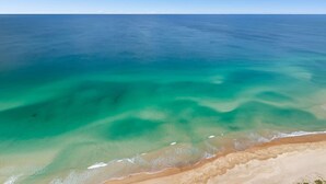 A beach with clear turquoise water and a sandy shore. - Stunning Beachfront level48 with parking /L (Surfers Paradise)