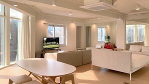 Un salon moderne avec une table à manger, un canapé et un téléviseur.