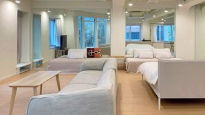 Une chambre d’hôtel moderne avec un grand lit, un canapé, une petite table et un téléviseur.