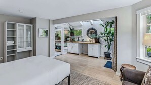 A bedroom with a bed, a wardrobe, a desk, and a large window with a view of greenery. - Cape Cod Home in Woodstock, Pet-Friendly & Wooded (Woodstock)