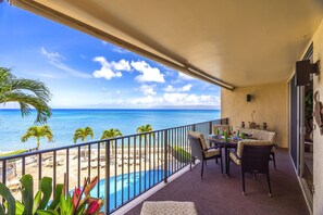 Ein Balkon mit Meerblick, ein Pool und Sitzmöglichkeiten im Freien.