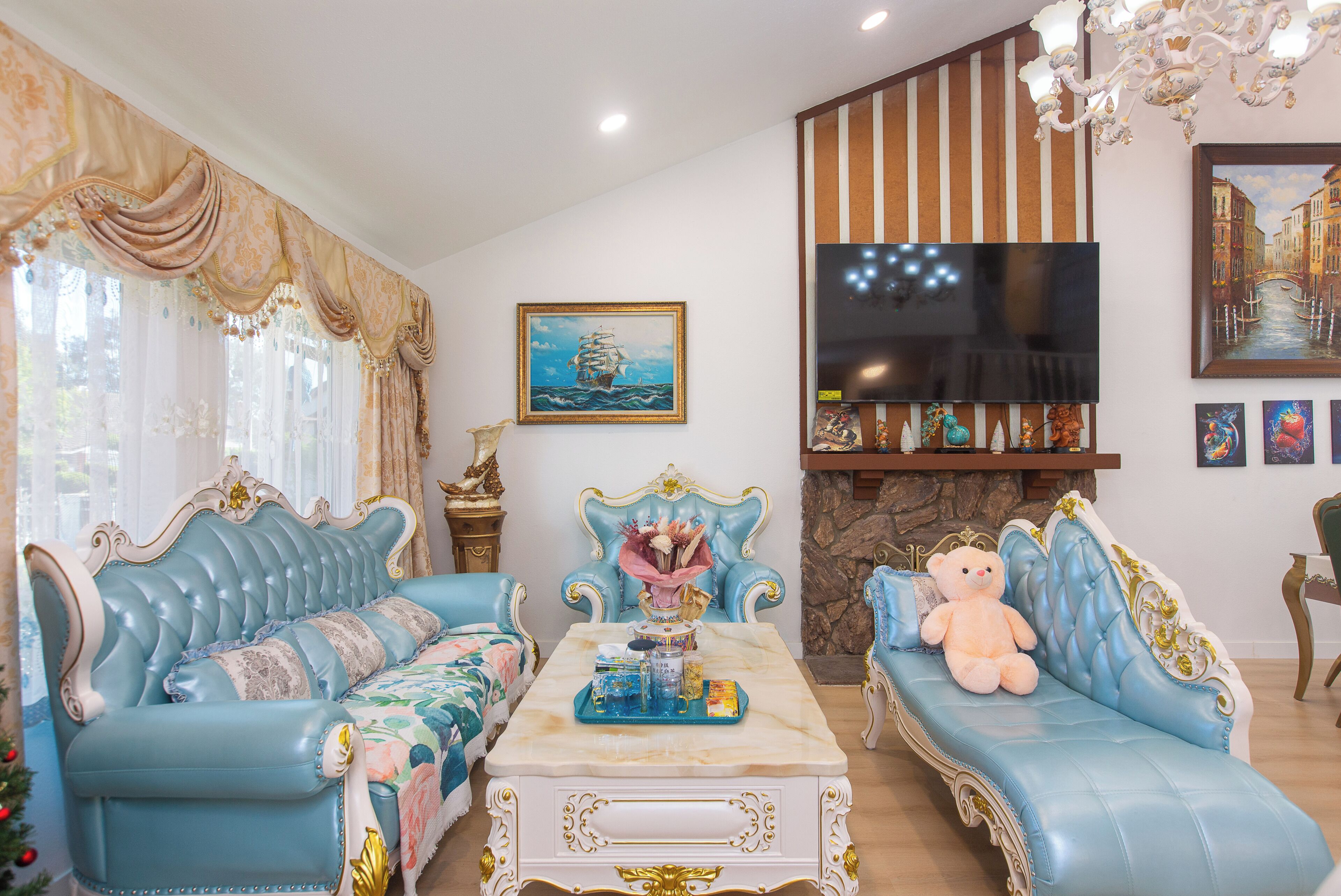 Una sala de estar con dos sofás azules, una mesa de centro, un televisor y una chimenea.