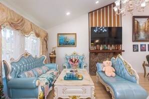 A living room with two blue sofas, a coffee table, a TV, and a fireplace. - Terrific 4-bedroom house with AC in West Covina (West Covina)