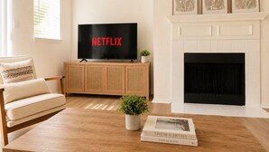 A living room with a television, a fireplace, a sofa, and a coffee table.