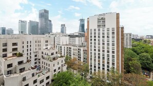A high-rise building with multiple floors, surrounded by greenery and other buildings. - Metro Świętokrzyska Simple Studio (Warszawa)