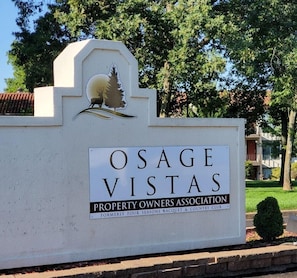 Schild für Osage Vistas, Eigentümervereinigung, mit einem Logo mit einem Reh und einem Baum.