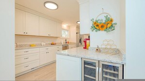 A modern kitchen with white cabinets, granite countertops, and a built-in oven. - The Beehive New 4 Bedroom Listing Next to CNU (Newport News)