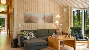Ein modernes Interieur mit Holzboden, einer Couch, einem Tisch und einem Stuhl.