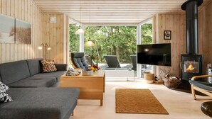 Ein gemütliches Wohnzimmer mit Sofa, Couchtisch, Fernseher und Kamin.