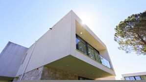 A modern building with a prominent corner design, large windows, and a balcony. - Sanpietro Vacation Villa 014 (Ishëm)