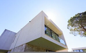 A modern building with a prominent corner design, large windows, and a balcony. - Sanpietro Vacation Villa 014 (Ishëm)