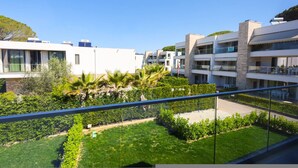 A modern apartment building with multiple balconies, a well-maintained garden, and a clear blue sky. - Sanpietro Vacation Villa 014 (Ishëm)