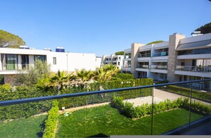 A modern apartment building with multiple balconies, a well-maintained garden, and a clear blue sky. - Sanpietro Vacation Villa 014 (Ishëm)