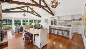 A spacious kitchen with a large island, wooden beams, and a chandelier. - “Southern Highlands Estate”, Private Rural Oasis. (Sutton Forest)