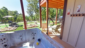 Ein Whirlpool mit Blick auf eine Terrasse, Gartenmöbel und eine Pergola.
