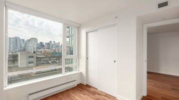 A room with a large window, white walls, and a radiator.