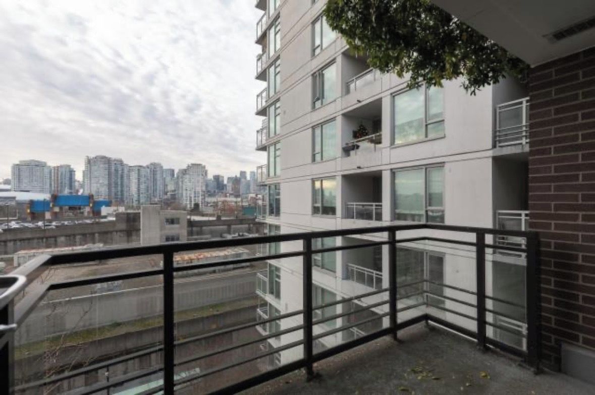 A high-rise building with multiple balconies, large windows, and a view of a cityscape.