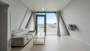 Una habitación moderna con sofá, una mesita de centro y vistas a la playa.
