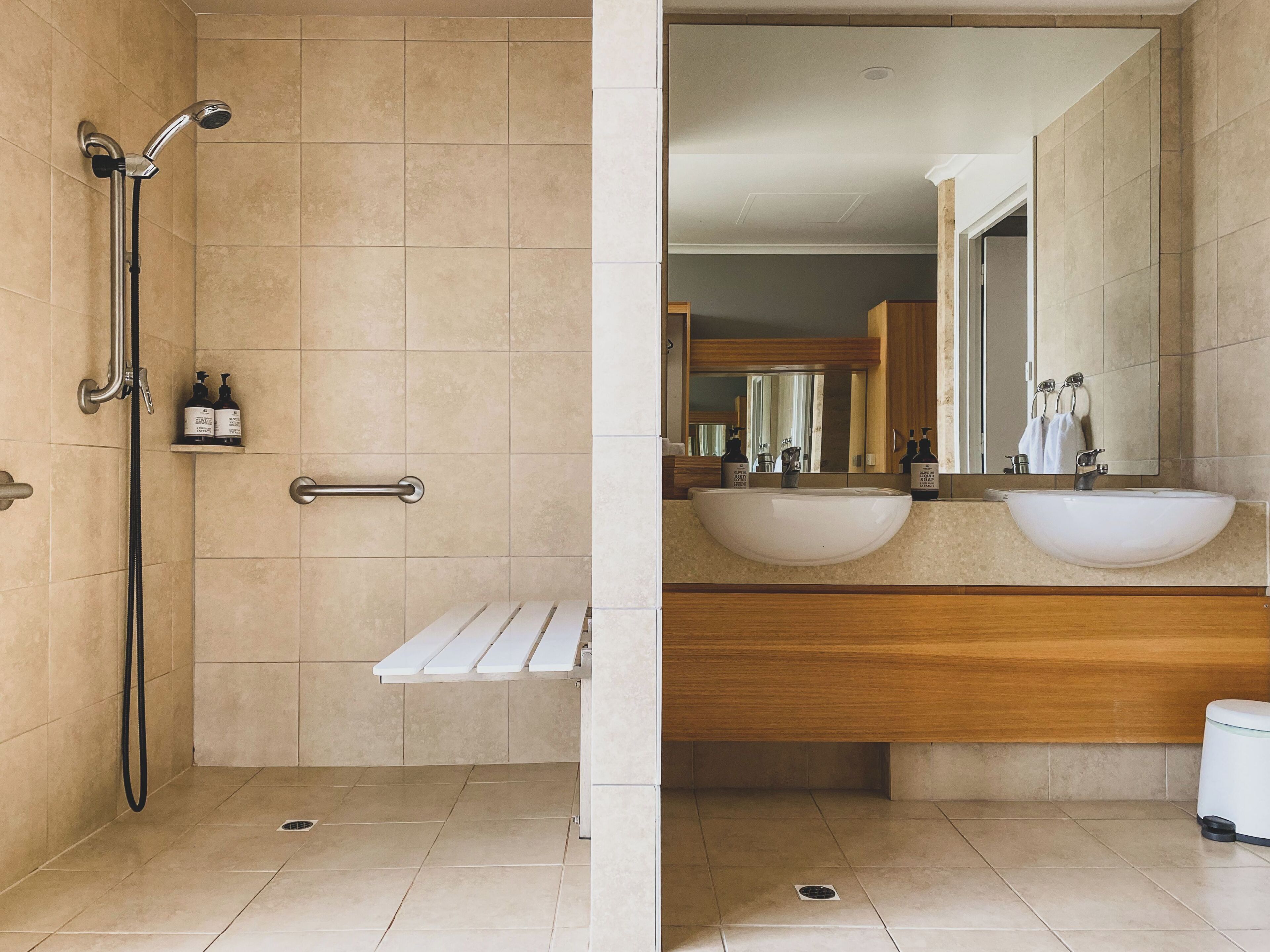 A modern bathroom with a shower, a sink, and a mirror.