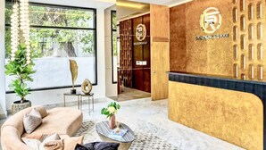 A modern reception area with a marble floor, a reception desk, and a seating area with a sofa and coffee table. - Modern Luxury Retreat Residence XX11 La Esperilla (Santo Domingo)
